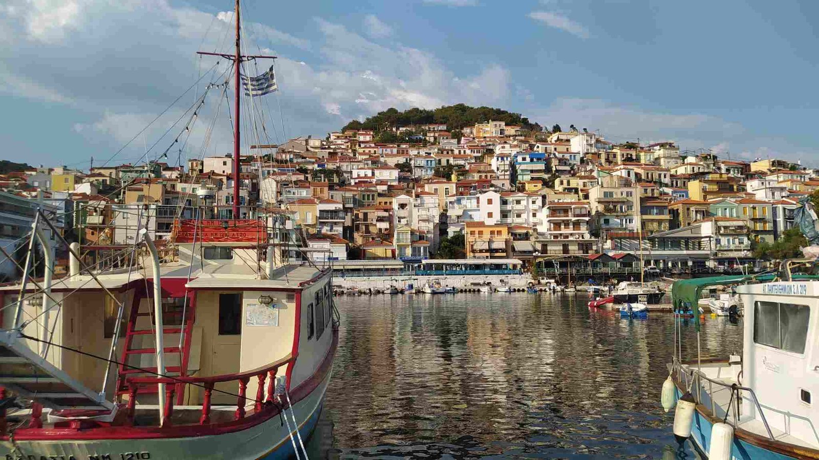 A fishing boat beneath the hillside houses of Plomari